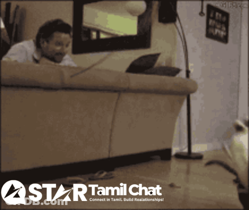 A Man Sitting On A Couch With A Laptop And A Star Tamil Chat Logo Behind Him GIF