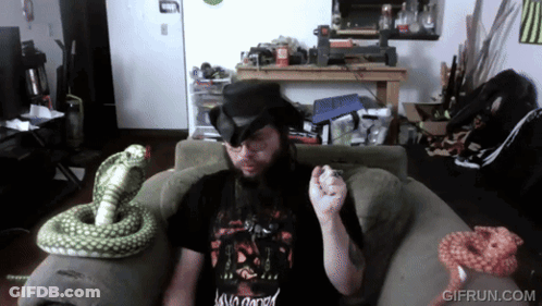 A Man Sitting On A Couch With A Snake And A Gif Run.com Logo GIF