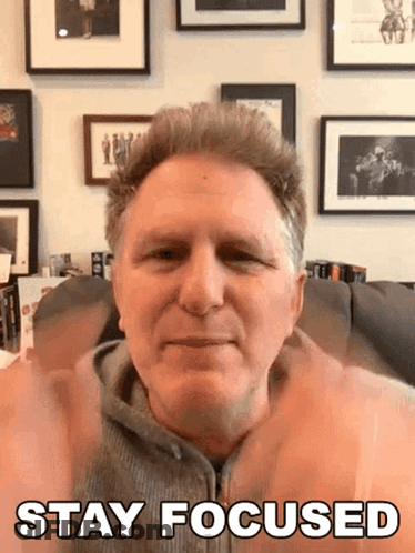 A Man Sitting On A Couch With His Hands Up And The Words Stay Focused Above Him GIF