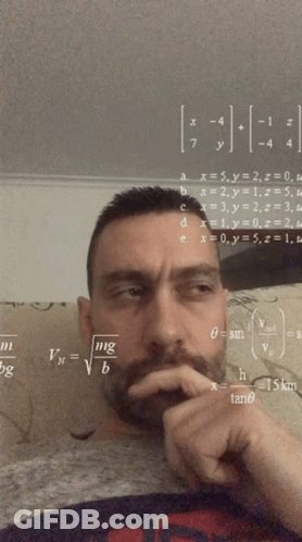 A Man Sitting On A Couch With Math Equations On The Wall GIF