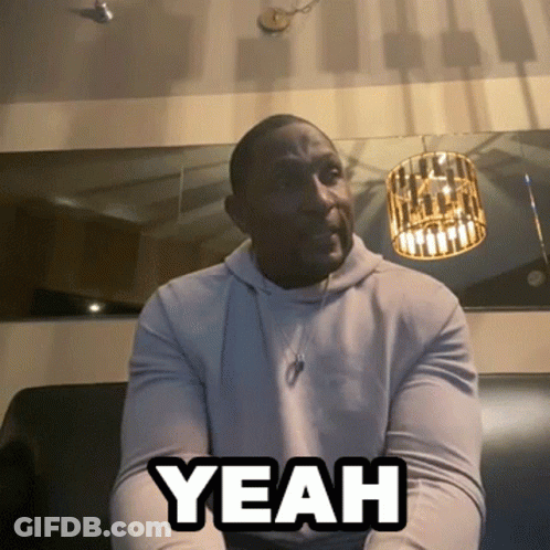 A Man Sitting On A Couch With The Word Yeah Written On His Chest GIF