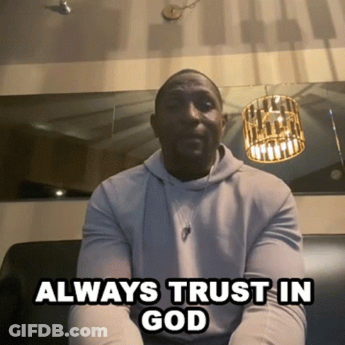 A Man Sitting On A Couch With The Words " Always Trust In God " Below Him GIF
