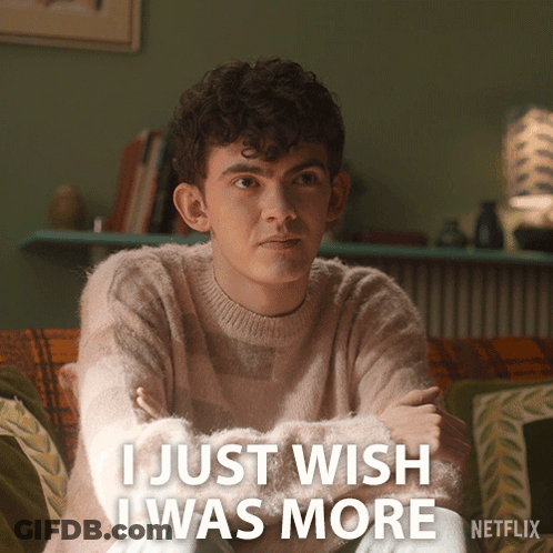 A Man Sitting On A Couch With The Words I Just Wish I Was More Written Below Him GIF