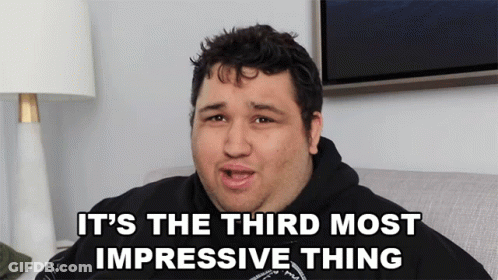 A Man Sitting On A Couch With The Words It 'S The Third Most Impressive Thing Above Him GIF