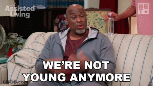 A Man Sitting On A Couch With The Words We 'Re Not Young Anymore GIF