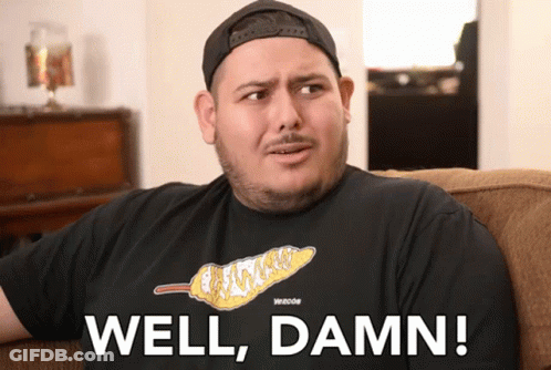 A Man Sitting On A Couch With The Words Well Damn Written On His Shirt GIF