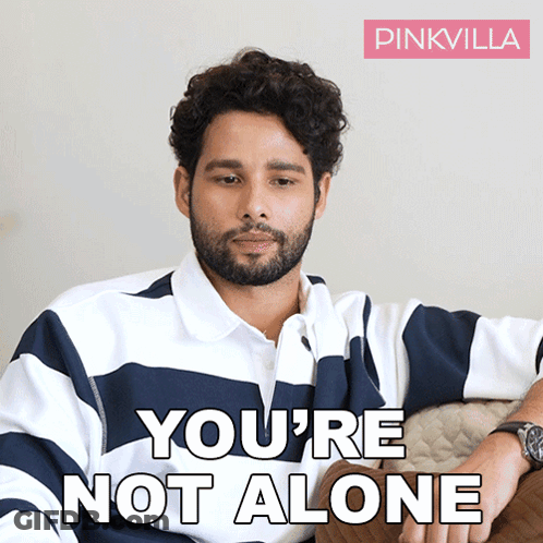 A Man Sitting On A Couch With The Words You 'Re Not Alone On The Bottom GIF