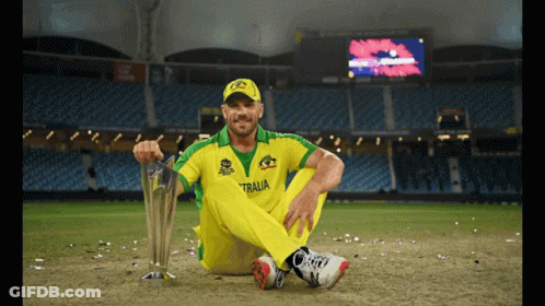 A Man Sitting On The Ground With A Trophy That Says Australia GIF