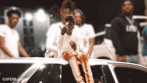 A Man Sitting On Top Of A Car Giving The Middle Finger To The Camera GIF