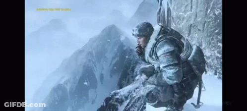 A Man Sitting On Top Of A Snow Covered Mountain Looking Out GIF