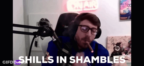 A Man Smoking A Cigar In Front Of A Microphone With The Words " Shills In Shambles " Written On The Bottom GIF