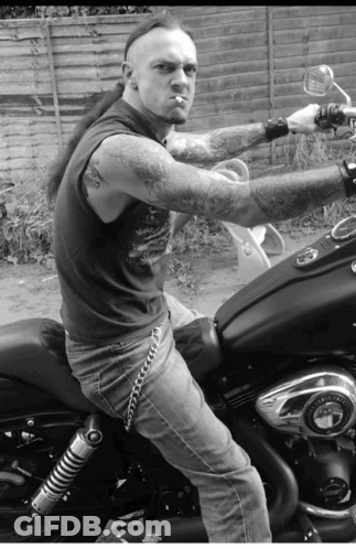 A Man Smoking A Cigarette While Riding A Motorcycle GIF