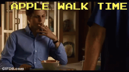 A Man Smoking A Cigarette While Sitting At A Table With The Words Apple Walk Time Above Him GIF
