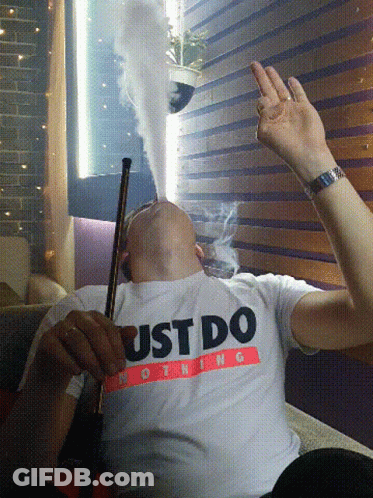 A Man Smoking A Hookah Wearing A Just Do Nothing Shirt GIF