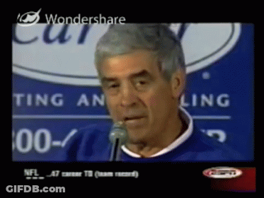 A Man Speaking Into A Microphone In Front Of A Sign That Says Ting An Ling GIF