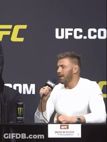A Man Speaking Into A Microphone In Front Of A Sign That Says Ufc On It GIF