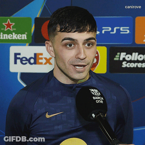 A Man Speaking Into A Microphone With A Fedex Logo In The Background GIF
