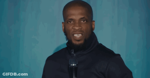 A Man Speaking Into A Microphone With His Mouth Open GIF