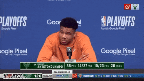 A Man Speaking Into A Microphone With Playoffs Written On The Screen Behind Him GIF