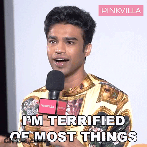 A Man Speaking Into A Microphone With The Words " I 'M Terrified Of Most Things " Above Him GIF