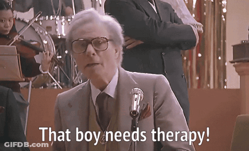 A Man Speaking Into A Microphone With The Words That Boy Needs Therapy Written Below Him GIF