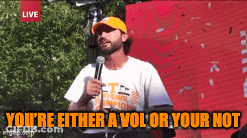A Man Speaking Into A Microphone With The Words You 'Re Either A Vol Or Your Not Below Him GIF