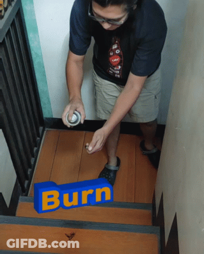 A Man Spray Paints A Blue Sign That Says Burn On A Set Of Stairs GIF