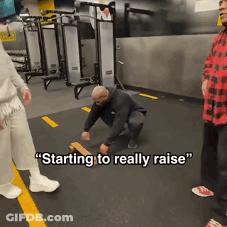 A Man Squatting Down In A Gym With The Words " Starting To Really Raise " Written On The Floor GIF