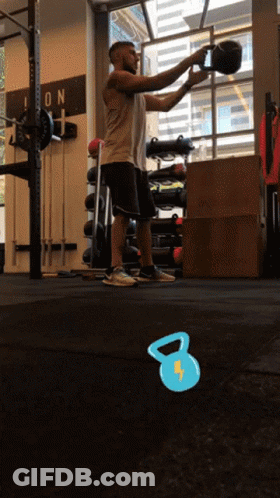 A Man Squatting In A Gym With A Sign On The Wall That Says Icon GIF
