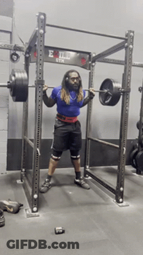 A Man Squatting With A Barbell In Front Of An Evil Gym Sign GIF