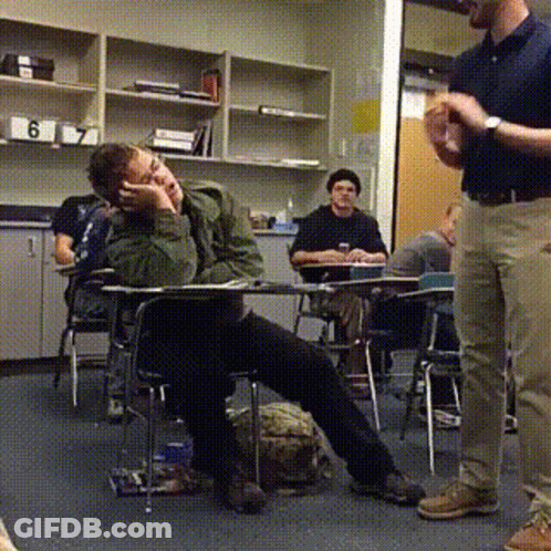 A Man Standing In A Classroom With The Number 6 On The Shelf GIF