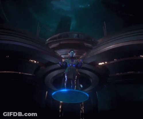 A Man Standing In A Dark Room With Blue Lights Coming Out Of His Hands GIF