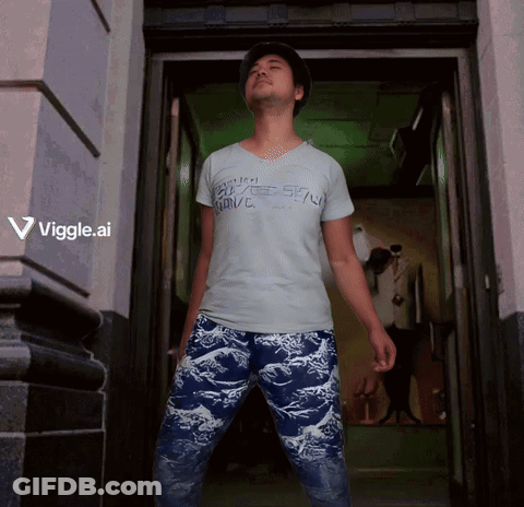 A Man Standing In A Doorway Wearing A Shirt That Says Viggle Ai GIF