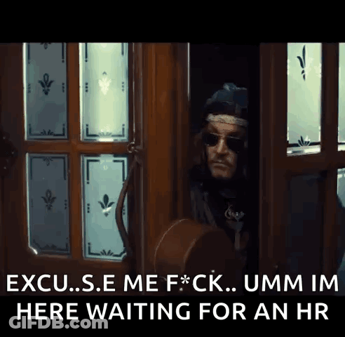 A Man Standing In A Doorway With The Words " Excuse Me F * Ck Umm Im Here Waiting For An Hr " Above Him GIF