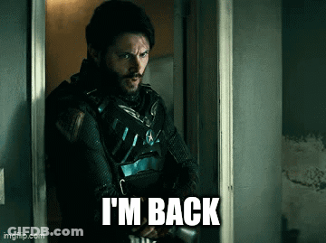 A Man Standing In A Doorway With The Words I 'M Back Written On The Bottom GIF