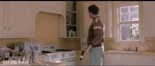 A Man Standing In A Kitchen Next To A Box That Says ' Paradise ' On It GIF