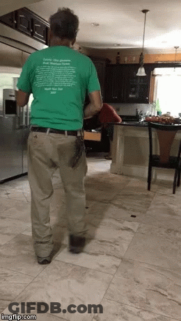 A Man Standing In A Kitchen Wearing A Green T-Shirt That Says " Delete Your Problems " On It GIF