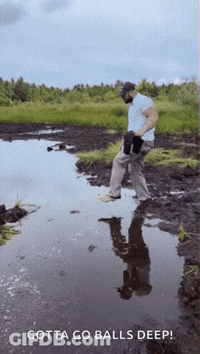 A Man Standing In A Muddy Puddle With The Words Gotta Go Balls Deep GIF