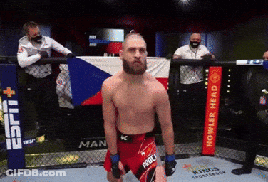 A Man Standing In A Ring With A Sign That Says Howler Head GIF