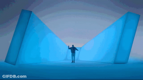 A Man Standing In A Room With A Purple Light GIF