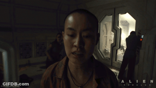 A Man Standing In A Room With The Word Alien On The Bottom GIF