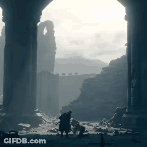 A Man Standing In A Ruined Building With A Sword GIF