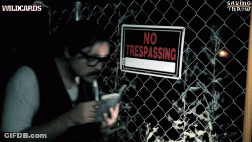 A Man Standing In Front Of A Barbed Wire Fence With A Sign That Says Sing On It GIF