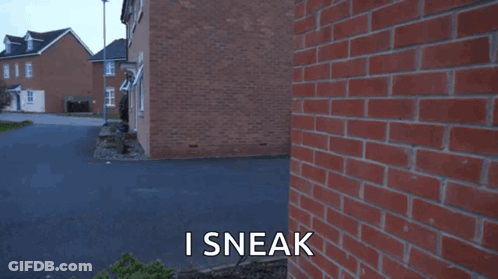 A Man Standing In Front Of A Brick Wall With The Words I Sneak Written On The Bottom GIF