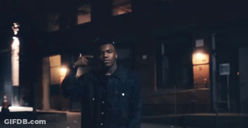 A Man Standing In Front Of A Building With A Sign That Says ' No Parking ' GIF