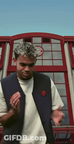 A Man Standing In Front Of A Building With A Sticker On It That Says ' Ucla ' GIF
