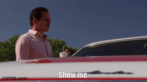 A Man Standing In Front Of A Car With The Words Show Me On The Hood GIF