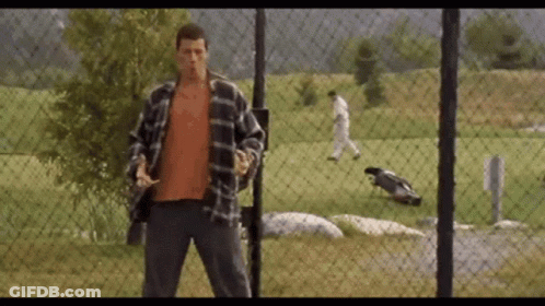 A Man Standing In Front Of A Chain Link Fence GIF