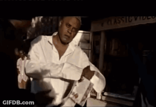 A Man Standing In Front Of A Classic Video Sign GIF