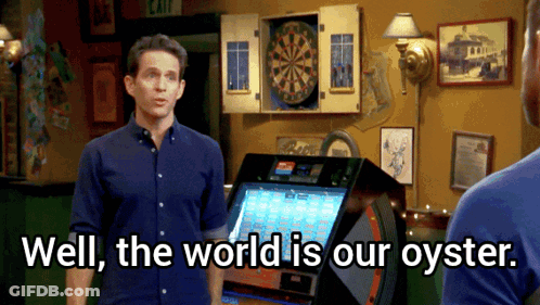 A Man Standing In Front Of A Dart Board With The Words Well The World Is Our Oyster GIF